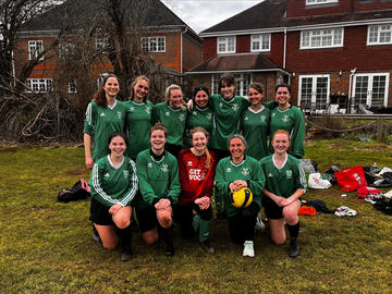 Holly profile photo Holly (second from right, front row) poses with her college football team. 11 women wearing green jerseys stand/kneel in two rows, with a woman in red jersey in the centre front.